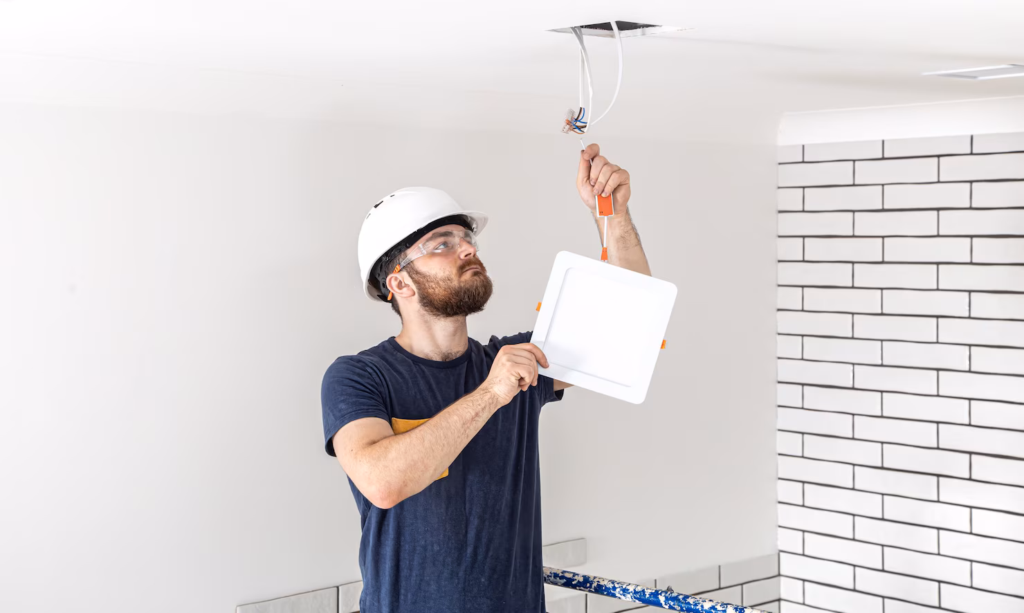 constructor electricista barba trabajador casco blanco trabajo instalacion lamparas altura profesional monos taladro sitio reparacion 169016 8629